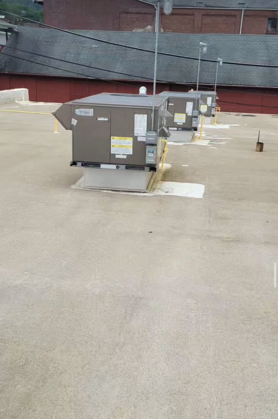Row of rooftop units fed by new yellow gas lines